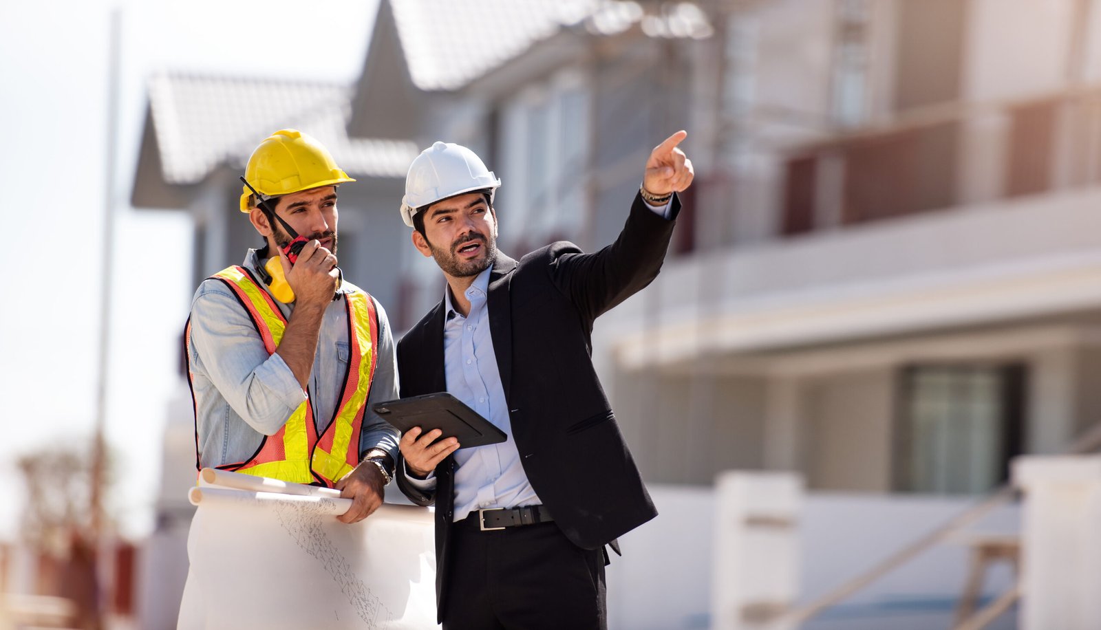Civil engineer and construction architecture worker are working in construction site with tablet and blueprints for planing about new construction site.Cooperation teamwork concept.